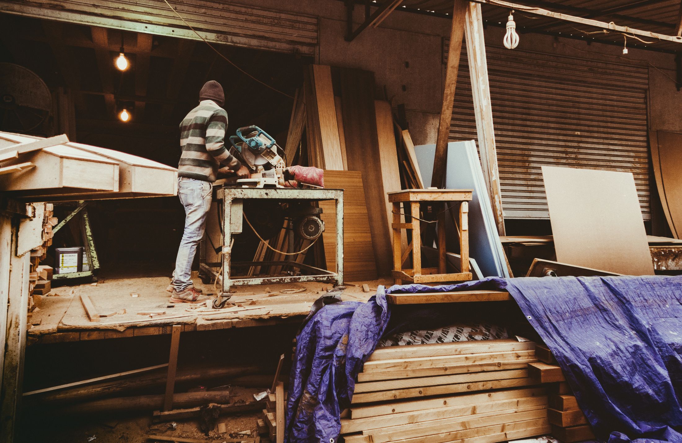 Illustrative photo of a carpenter working with a miter saw in a workshop